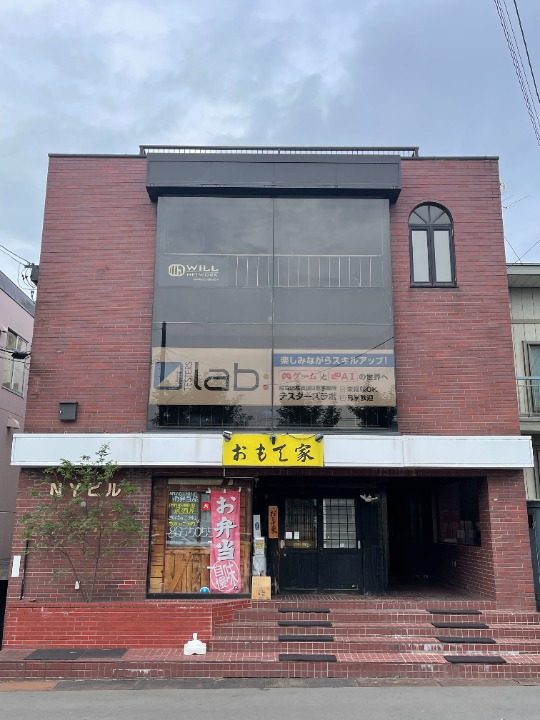 道案内2: 右側に「テスターズラボ」の看板が見えます。建物の右側の階段を上がり、2階の扉が「テスターズラボ」です